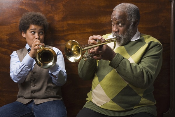 Grandfather and boy playing the trumpet together.